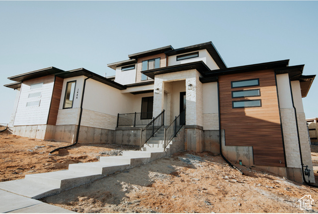 View of front of house featuring stone siding and stucco siding