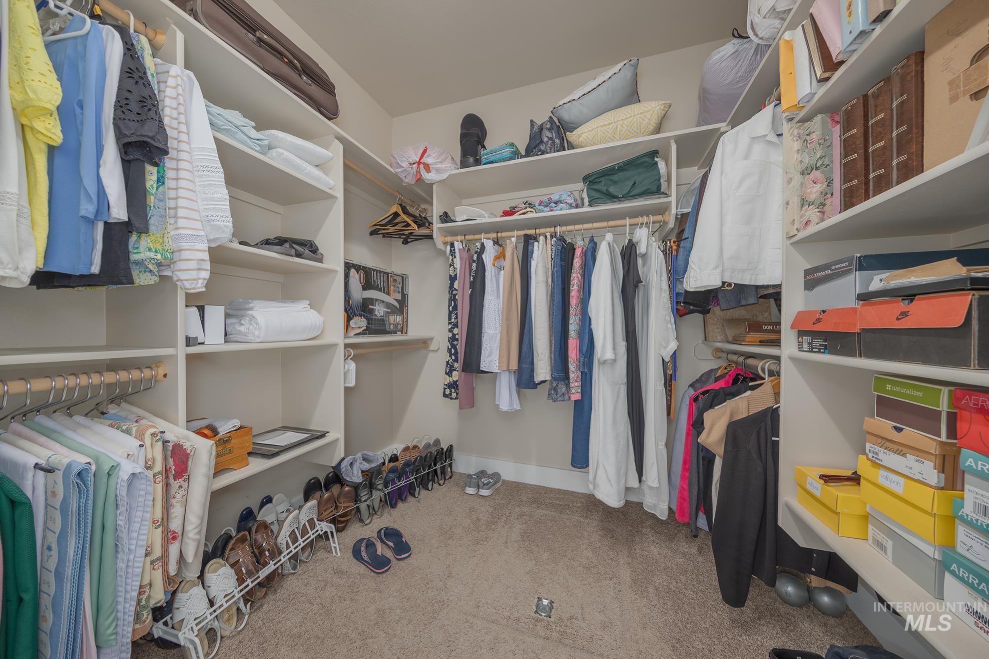 420 West Indianhead Road Weiser, ID 83672 - Photo 27 of 40 Walk-in closet featuring built-in shelving, multiple hanging rods, and neutral-toned carpeting