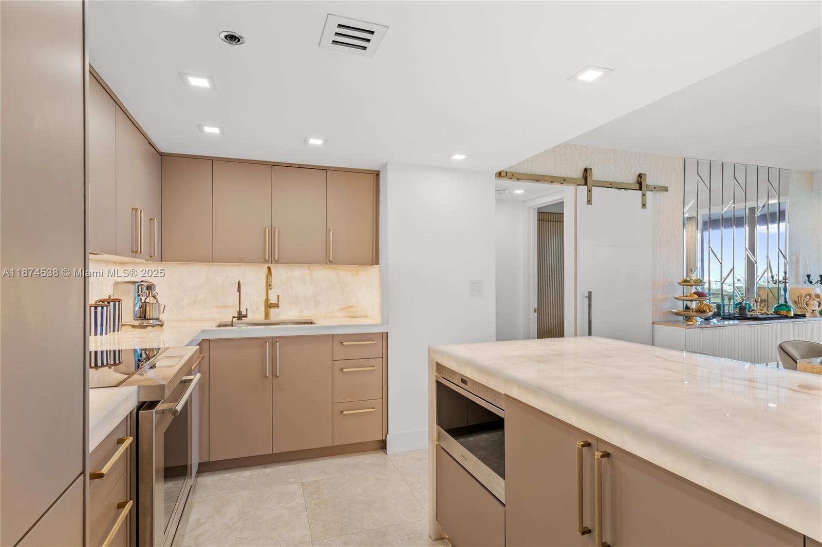 2025 Brickell Avenue, Unit 1705 Miami, FL 33129 - Photo 11 of 50 a kitchen with a sink a stove a refrigerator and white cabinets