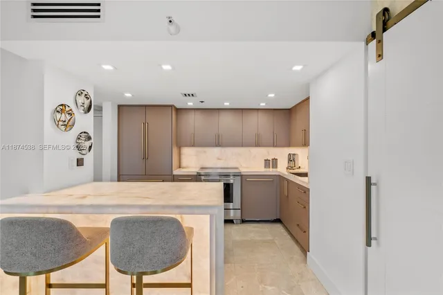 a kitchen with kitchen island a stove a sink and a refrigerator