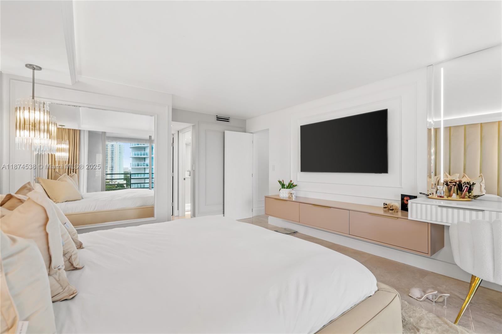 2025 Brickell Avenue, Unit 1705 Miami, FL 33129 - Photo 17 of 50 a spacious bedroom with a bed and a flat screen tv