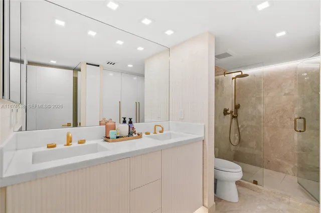 a bathroom with a double vanity sink toilet and shower