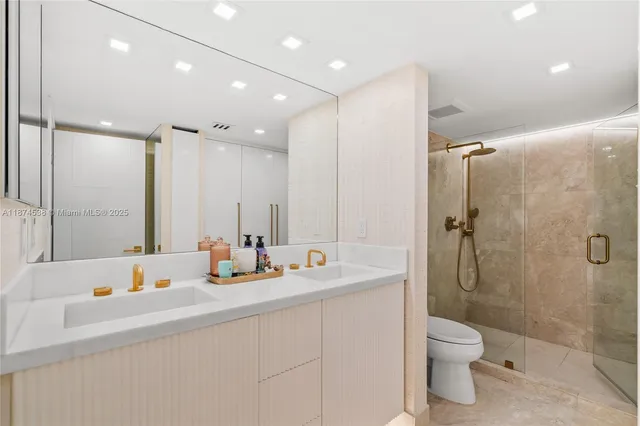 a bathroom with a double vanity sink toilet and shower