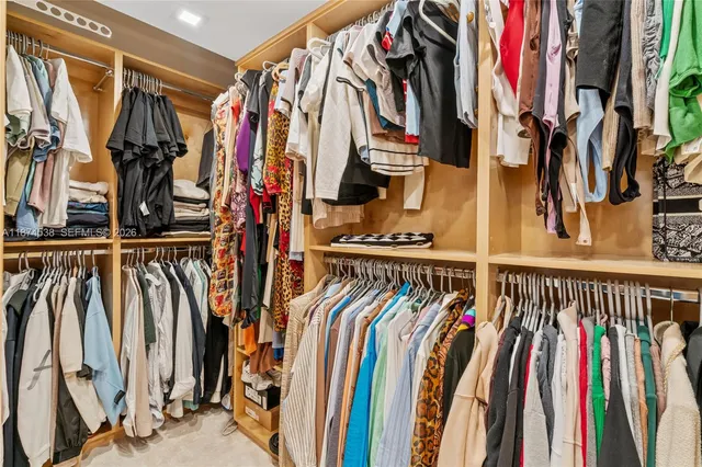 a view of walk in closet with clothes