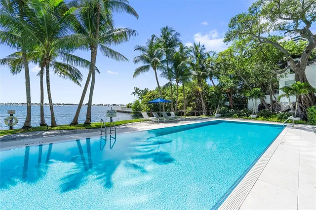 a view of a swimming pool with a yard and plants