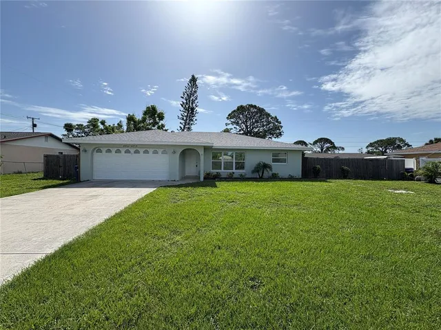 a front view of a house with a garden and yard