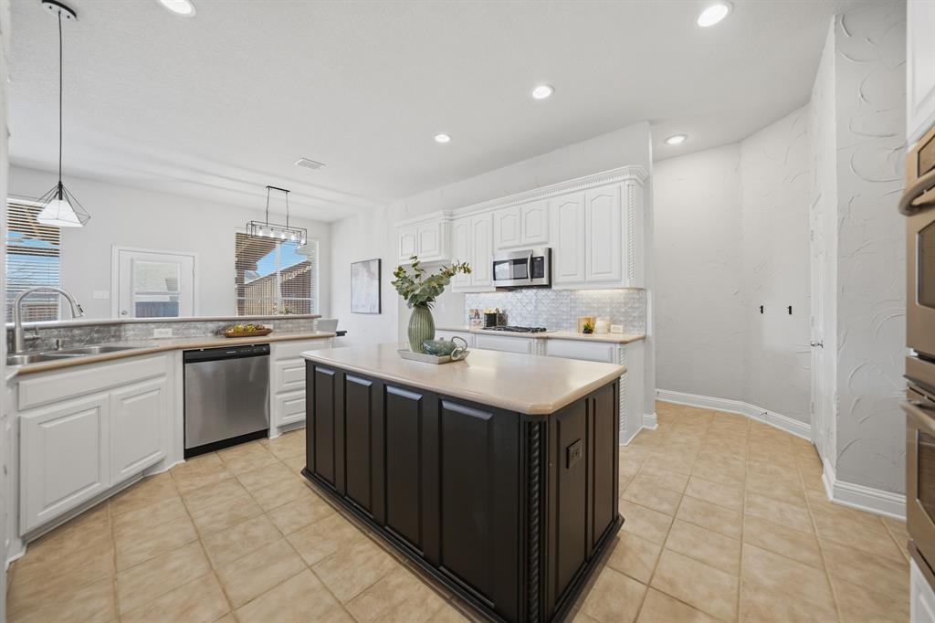 3475 Pilgrim Drive Frisco, TX 75034 - Photo 14 of 33 a kitchen with stainless steel appliances granite countertop a sink and dishwasher a stove top oven with white cabinets