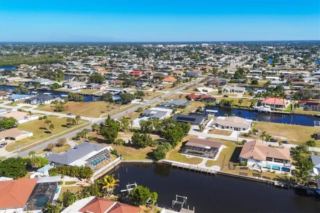 an aerial view of a city with lots of residential buildings and ocean view in back