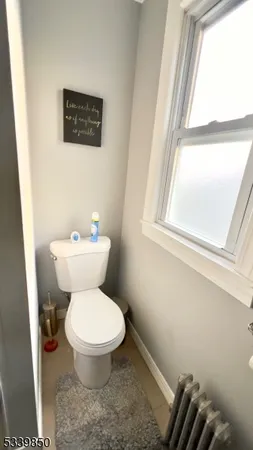 a white toilet sitting next to a window