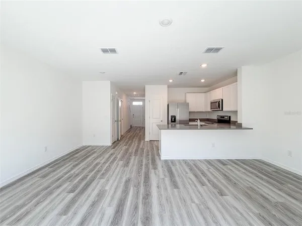 a view of kitchen with sink and refrigerator