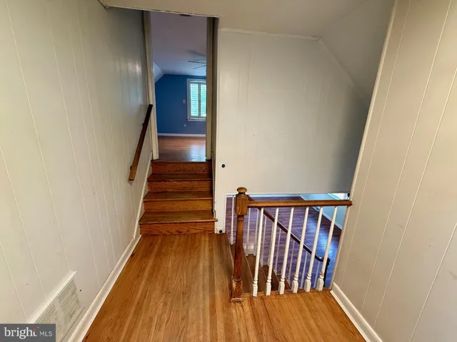 a view of a hallway with wooden floor and staircase