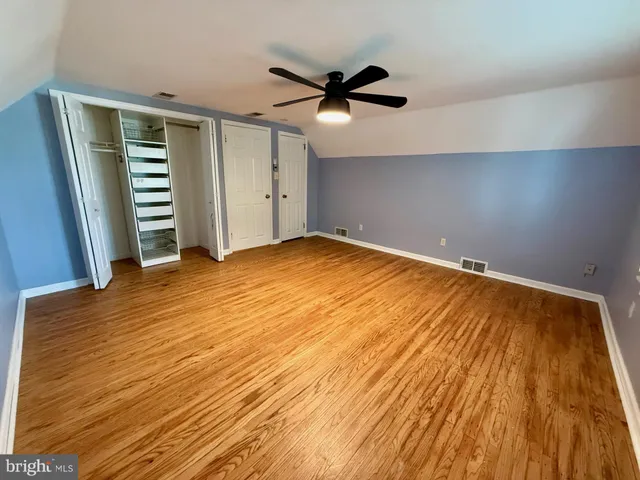 a view of a room with wooden floor and ceiling fan