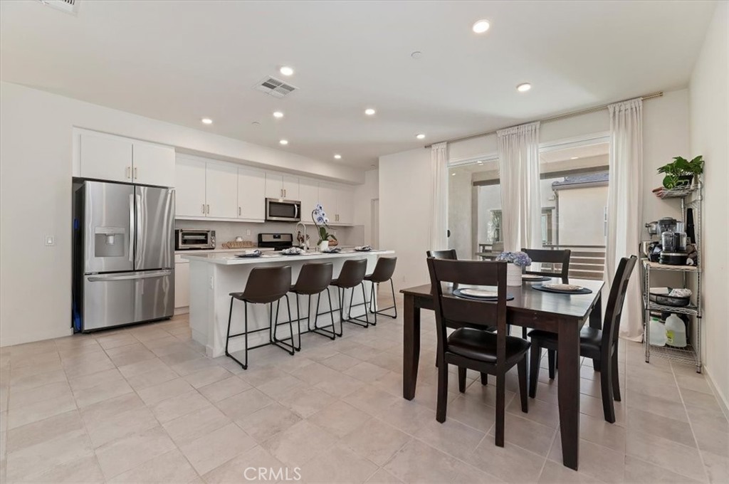 11012 Serenity Drive Rancho Cucamonga, CA 91730 - Photo 2 of 37 a view of kitchen with refrigerator a dining table and chairs