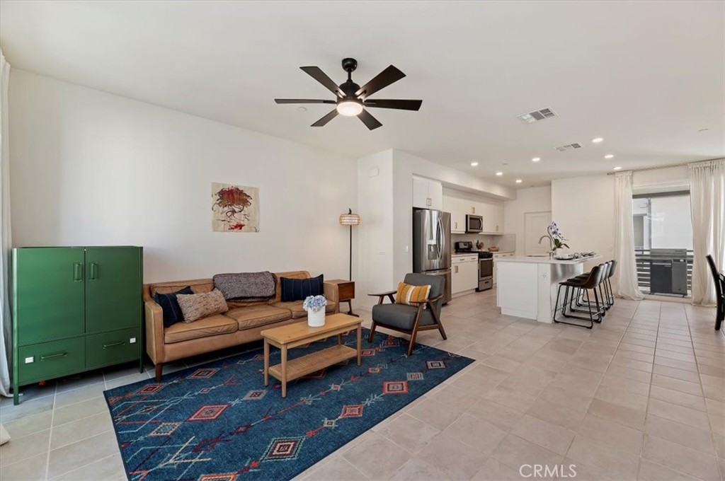 11012 Serenity Drive Rancho Cucamonga, CA 91730 - Photo 9 of 37 a living room with furniture kitchen view and a chandelier