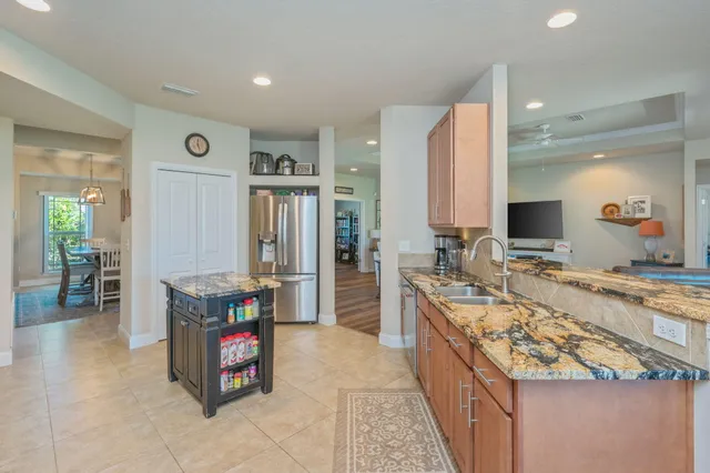 a large kitchen with stainless steel appliances granite countertop a large counter top a stove and a refrigerator