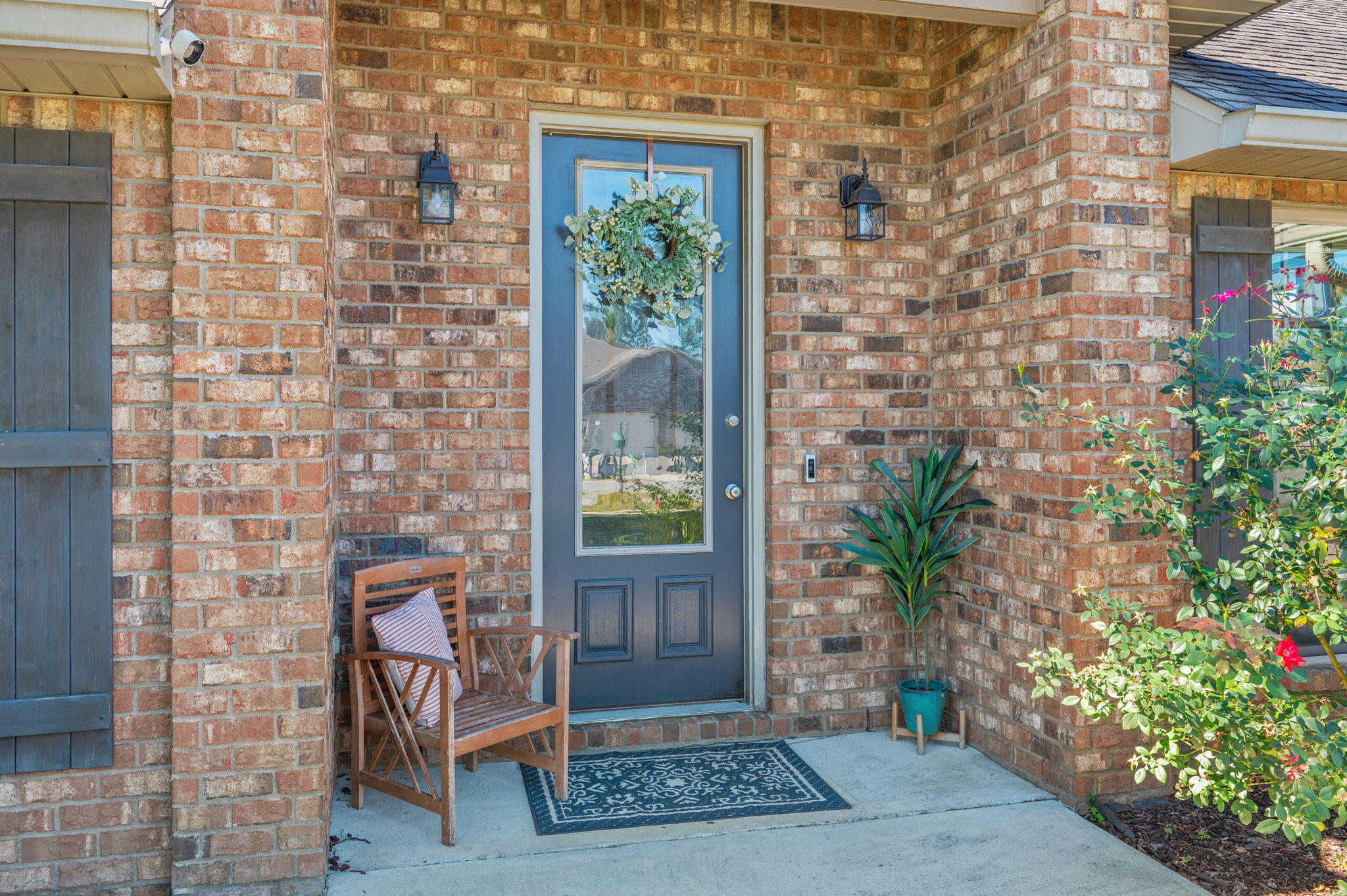 4675 Chanteuse Parkway Crestview, FL 32539 - Photo 2 of 48 a brick building with a bench and potted plants