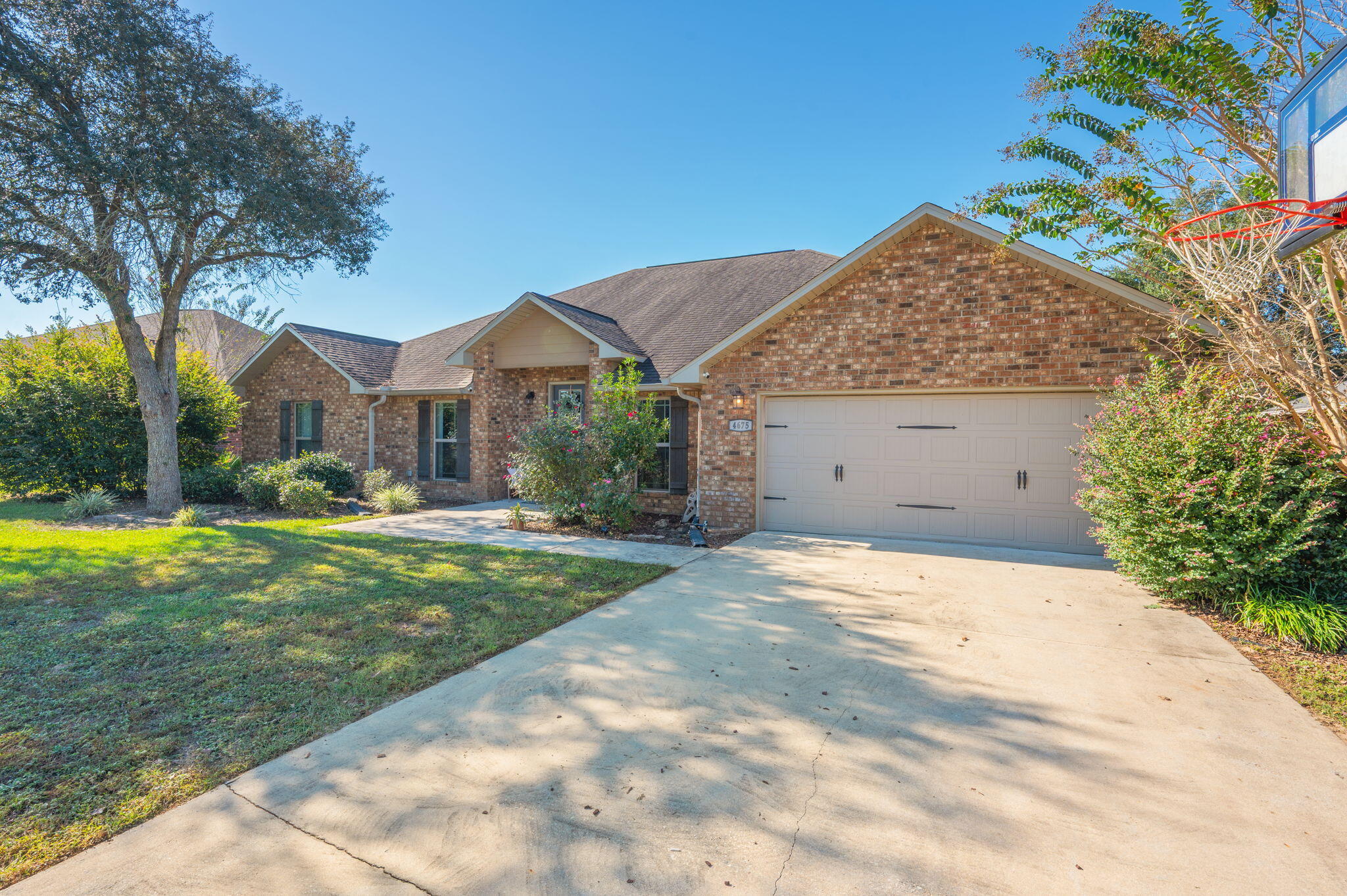 4675 Chanteuse Parkway Crestview, FL 32539 - Photo 5 of 48 a backyard of a house with table and chairs plants and large tree