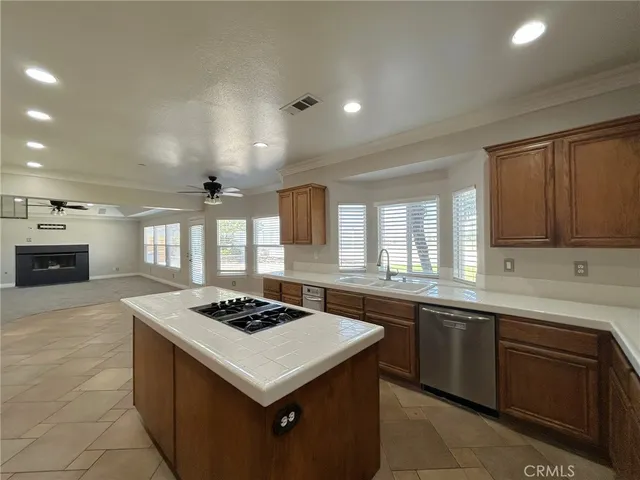 a large kitchen with stainless steel appliances granite countertop a sink and cabinets