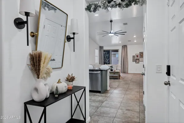 a view of a hallway with furniture and a chandelier
