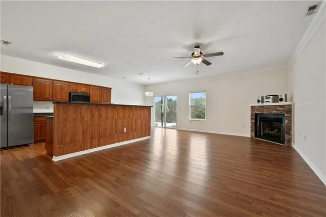 a view of an empty room with a kitchen and a window