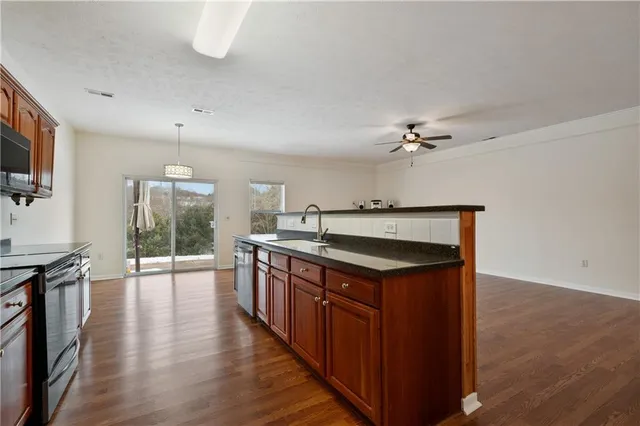 a kitchen with stainless steel appliances granite countertop a sink and wooden cabinets