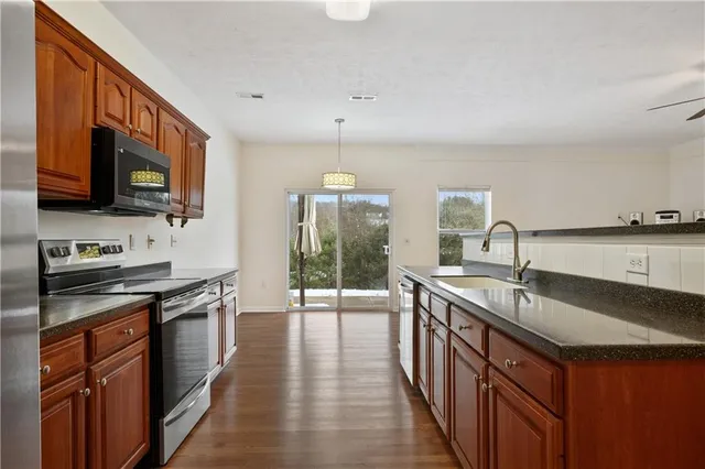 a kitchen with stainless steel appliances granite countertop a sink stove and cabinets
