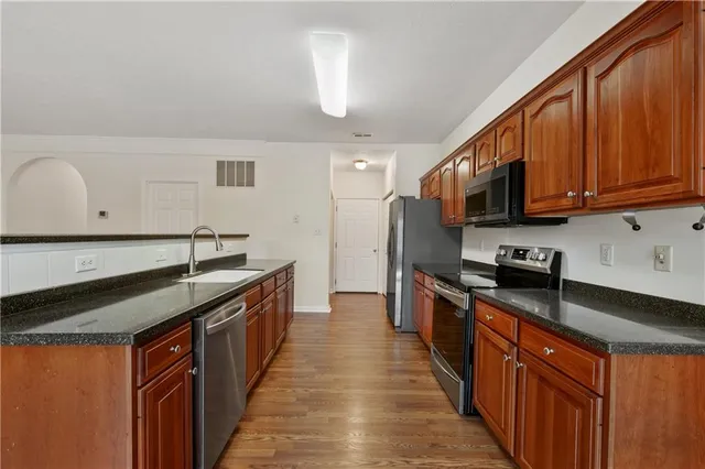 a kitchen with stainless steel appliances granite countertop a stove a sink dishwasher and a refrigerator