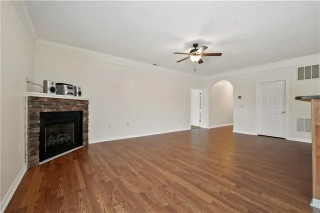 a view of empty room with fireplace and wooden floor