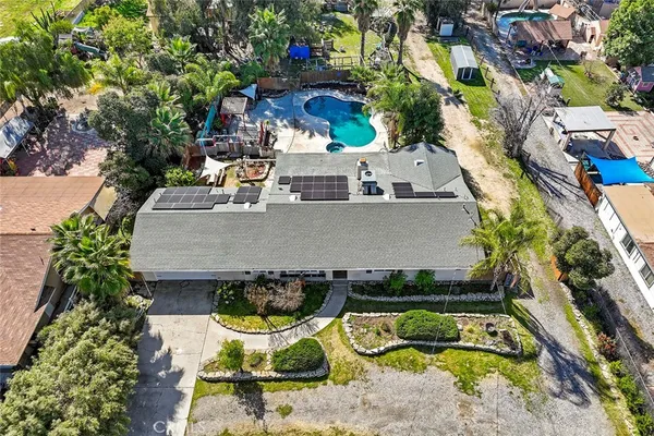 an aerial view of a house with swimming pool and outdoor seating