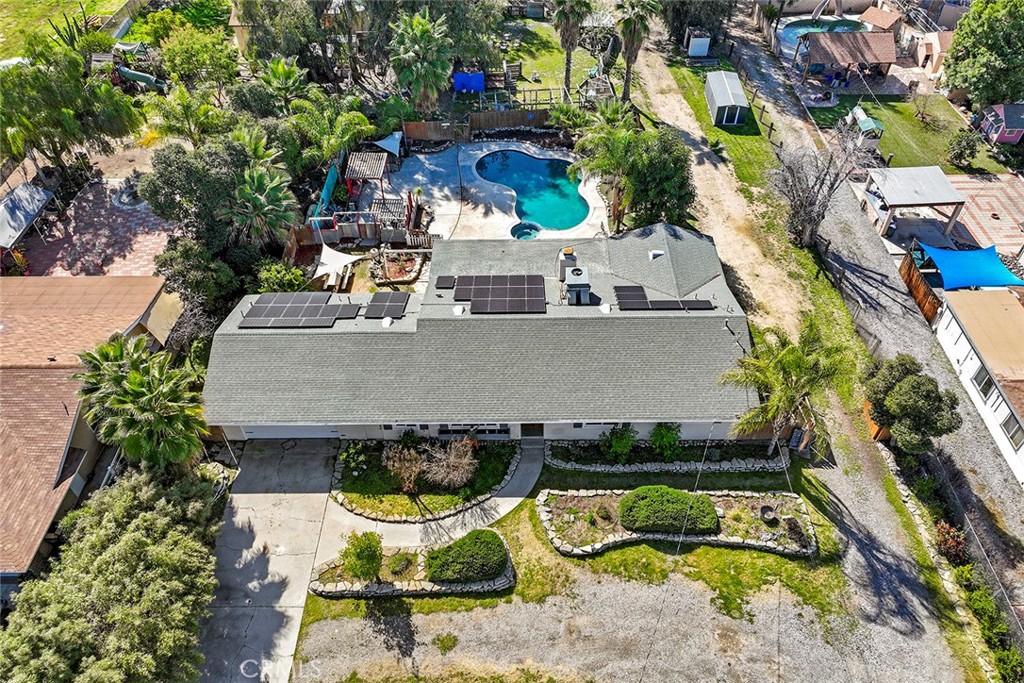 an aerial view of a house with swimming pool and outdoor seating