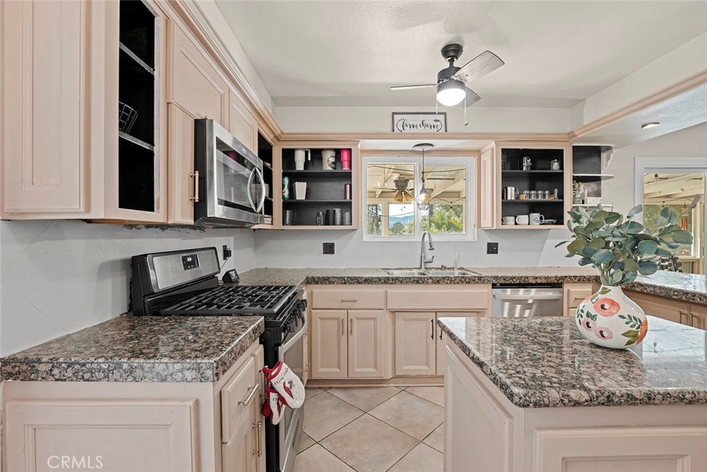40069 East Newport Road Hemet, CA 92543 - Photo 12 of 64 a kitchen with stainless steel appliances granite countertop a sink stove and cabinets