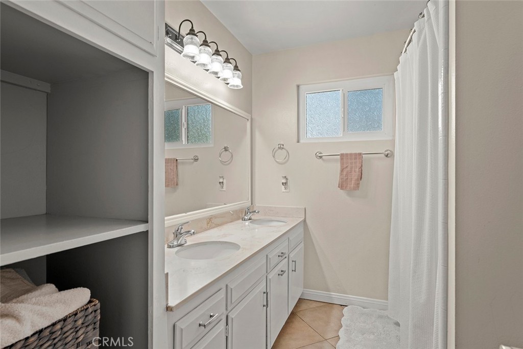40069 East Newport Road Hemet, CA 92543 - Photo 23 of 64 a spacious bathroom with a granite countertop sink a mirror and a shower