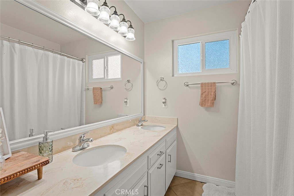 40069 East Newport Road Hemet, CA 92543 - Photo 24 of 64 a bathroom with a double vanity sink and a mirror