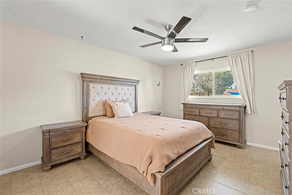 40069 East Newport Road Hemet, CA 92543 - Photo 26 of 64 a bedroom with a bed a window and a chandelier