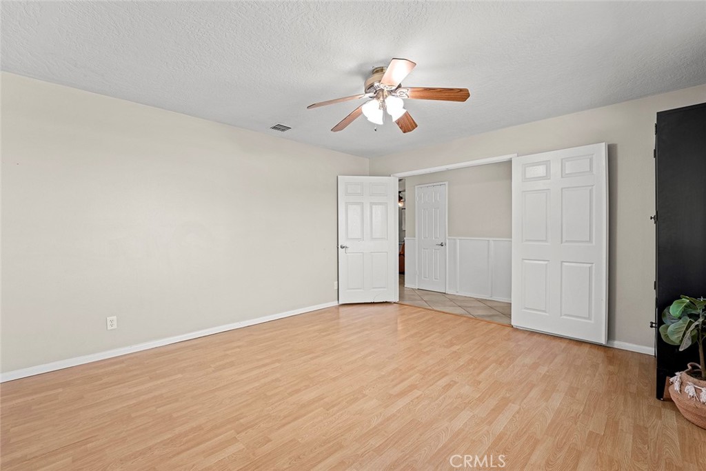 40069 East Newport Road Hemet, CA 92543 - Photo 5 of 64 a view of an empty room with wooden floor and a window