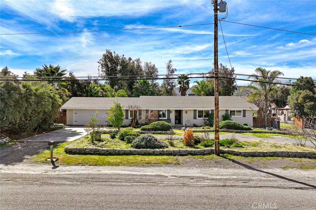 40069 East Newport Road Hemet, CA 92543 - Photo 51 of 64 a front view of a house with a garden and plants