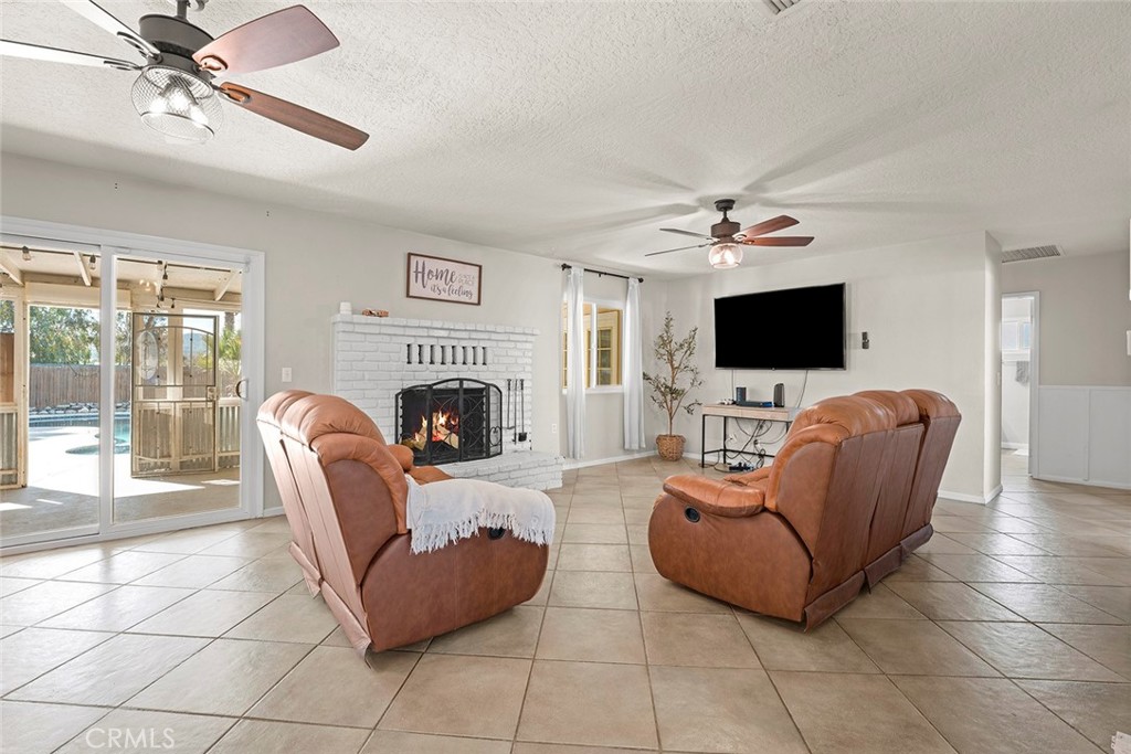 40069 East Newport Road Hemet, CA 92543 - Photo 6 of 64 a living room with furniture a fireplace and a flat screen tv