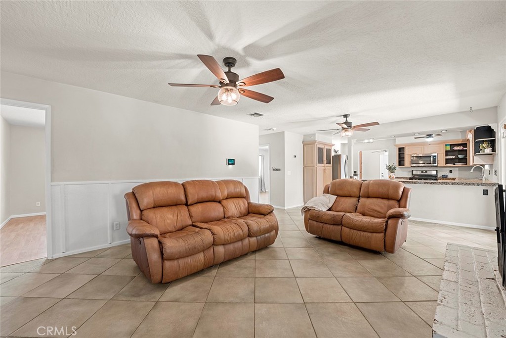40069 East Newport Road Hemet, CA 92543 - Photo 8 of 64 a living room with furniture a ceiling fan and a rug