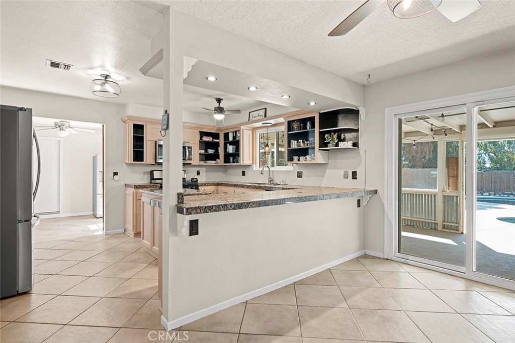40069 East Newport Road Hemet, CA 92543 - Photo 10 of 64 a large white kitchen with stainless steel appliances kitchen island granite countertop a refrigerator and a sink