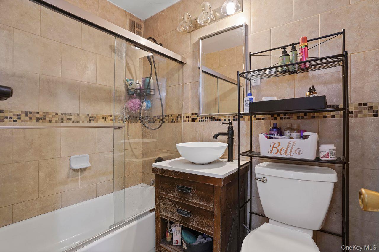 1190 East 53rd Street, Unit 2A Brooklyn, NY 11234 - Photo 5 of 11 a bathroom with a sink a toilet and shower