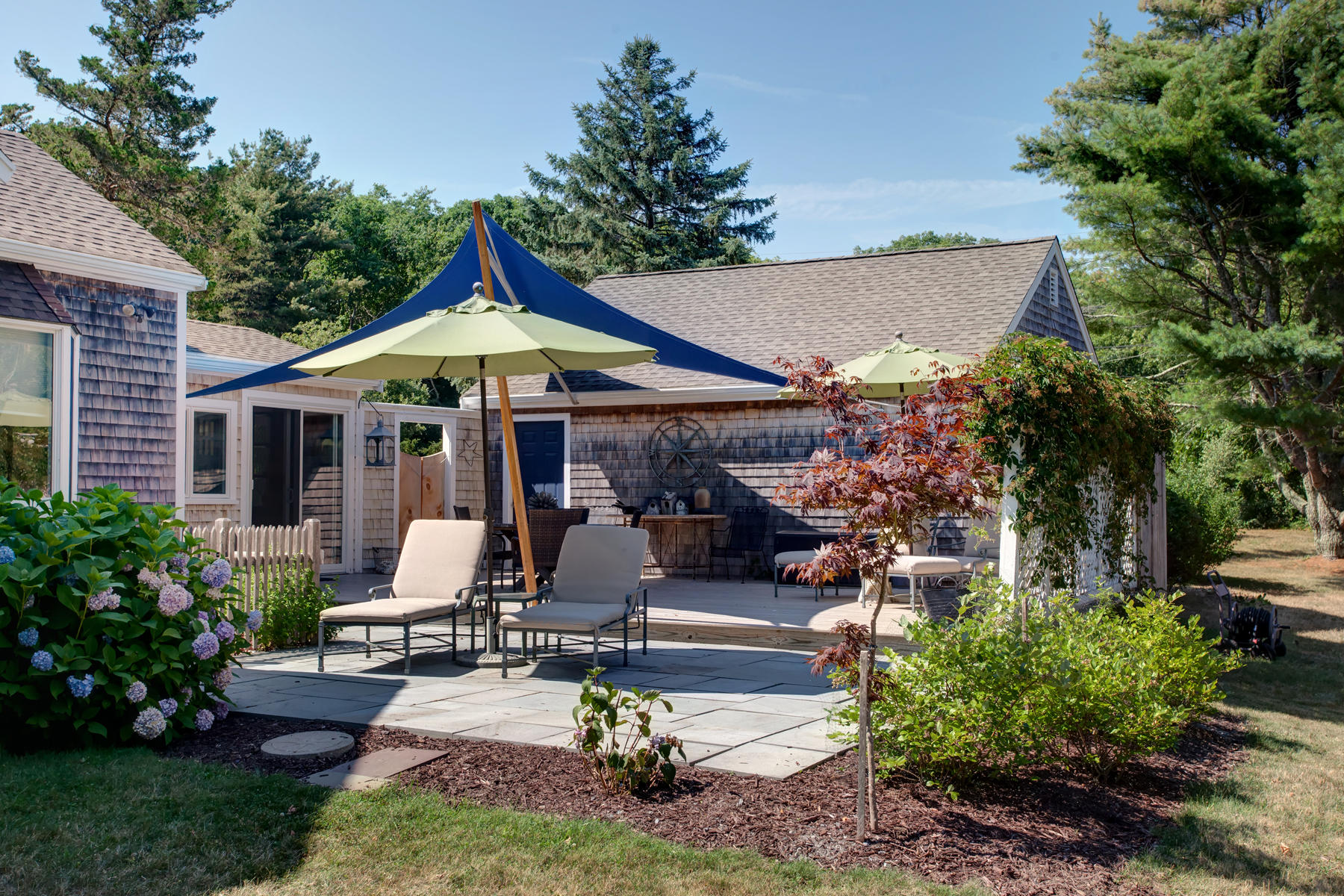 2 Plow Penny Road Bourne, MA 02532 - Photo 11 of 32 a view of a patio with table and chairs potted plants and large tree