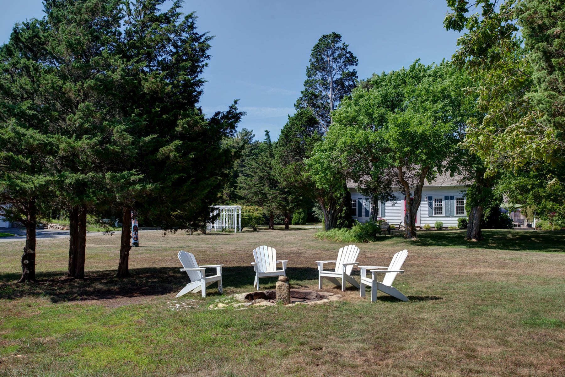 2 Plow Penny Road Bourne, MA 02532 - Photo 8 of 32 a view of a park with lawn chairs and a fire pit
