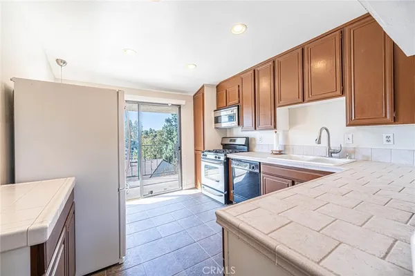 a kitchen with stainless steel appliances granite countertop a refrigerator and a sink