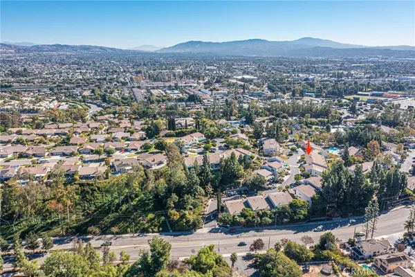 an aerial view of residential houses with outdoor space and trees