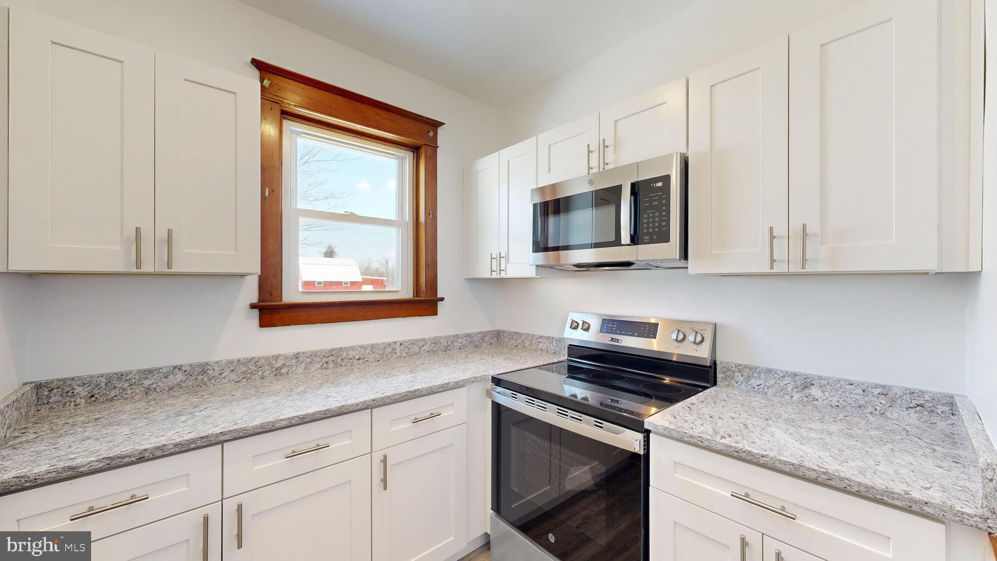 213 Broad Street St. Georges, DE 19733 - Photo 14 of 66 a kitchen with stainless steel appliances granite countertop white cabinets and a window