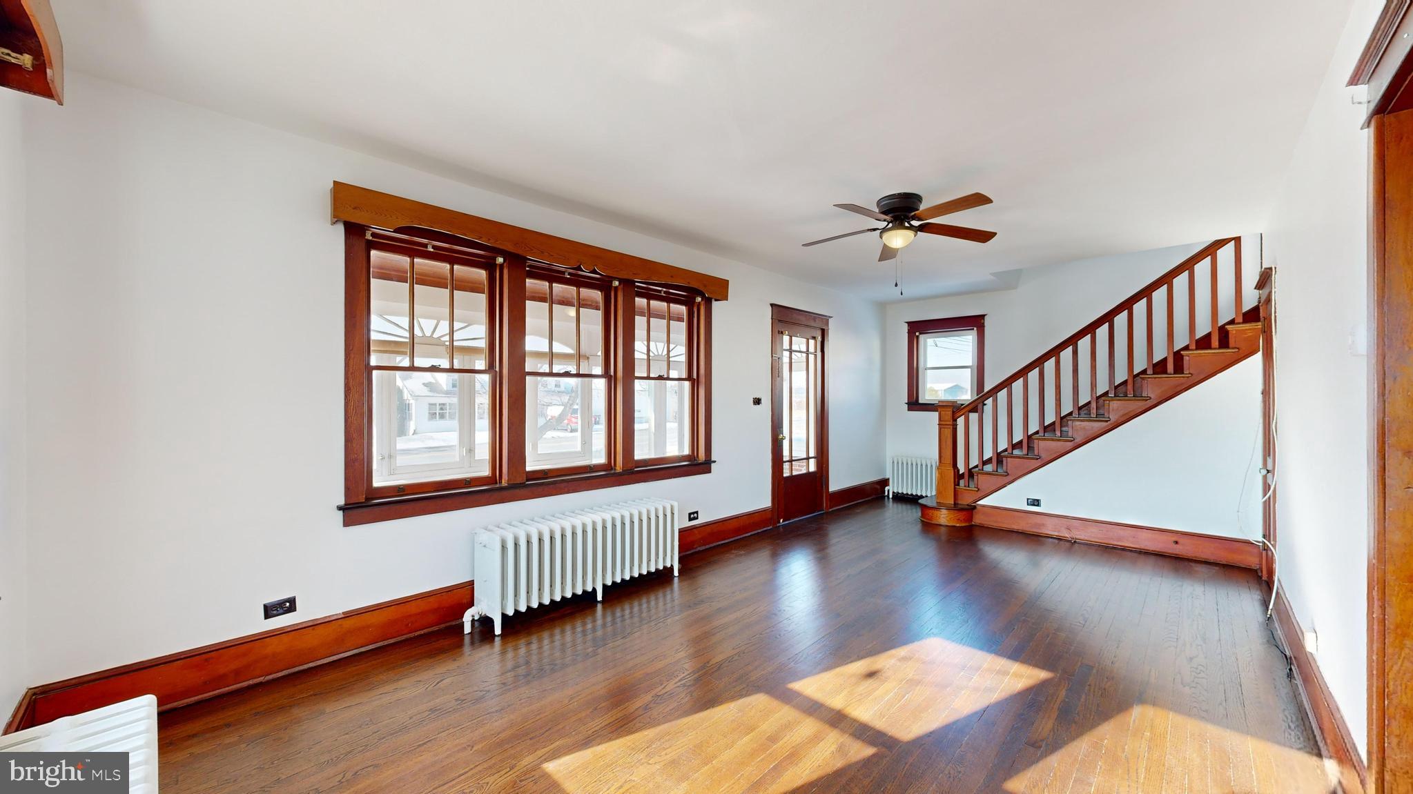 213 Broad Street St. Georges, DE 19733 - Photo 6 of 66 a view of a livingroom with wooden floor and a ceiling fan
