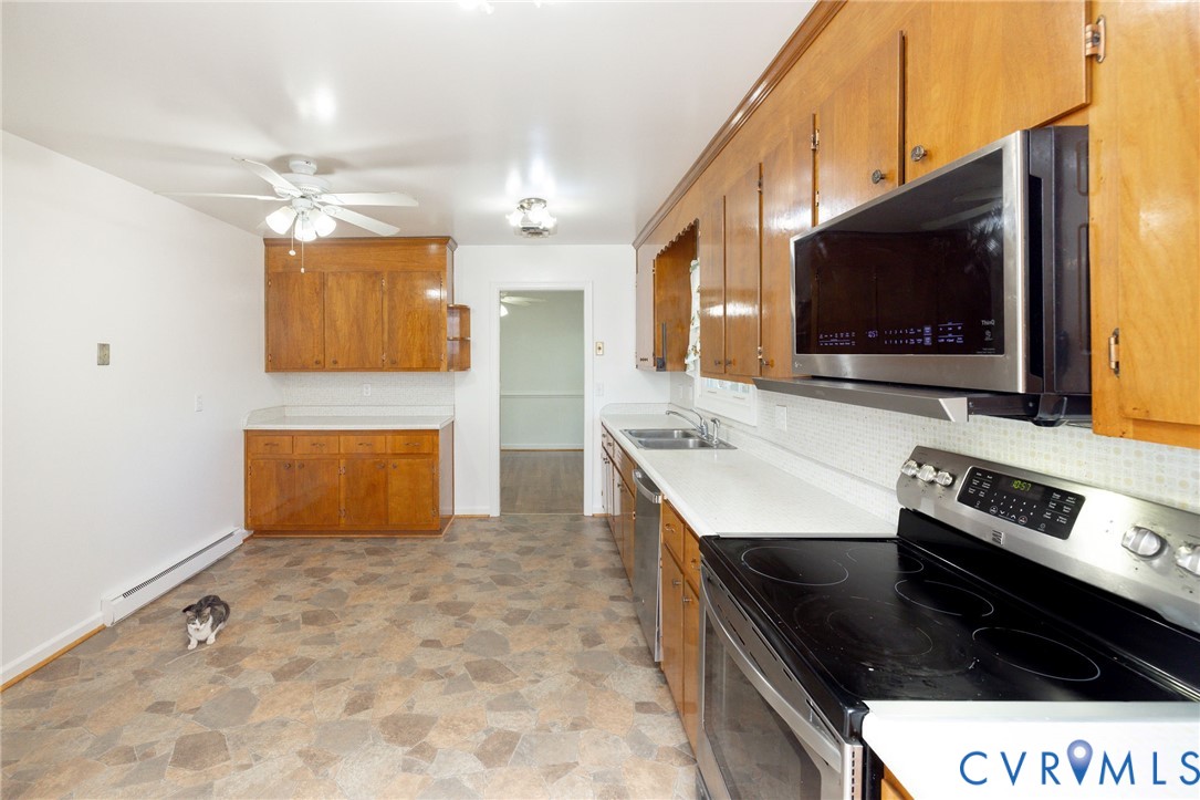 1210 Wellington Road Colonial Heights, VA 23834 - Photo 13 of 46 a kitchen with stainless steel appliances a stove a microwave and white cabinets