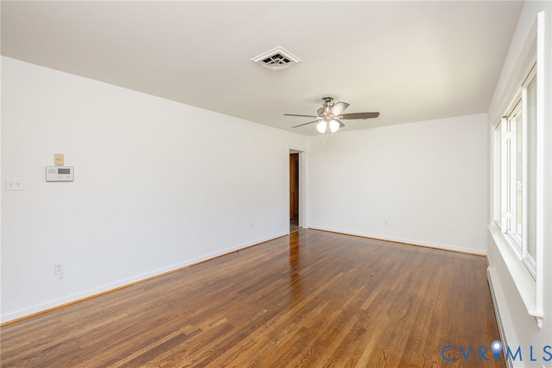 1210 Wellington Road Colonial Heights, VA 23834 - Photo 9 of 46 an empty room with wooden floor fan and windows