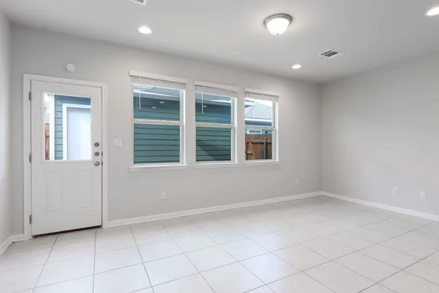 an empty room with closet area and windows