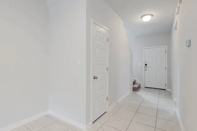 a view of an empty room with closet and a bathroom